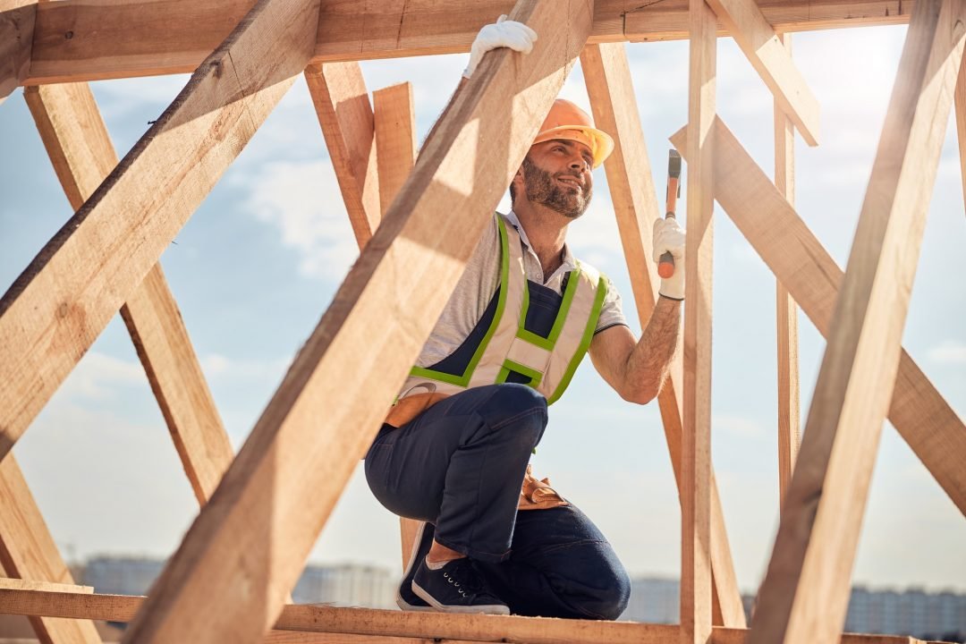 Image d'un homme de chantier avec un marteau qui construit une charpente